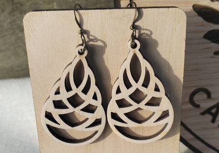 Wooden earrings on a wooden stand with a blurred background