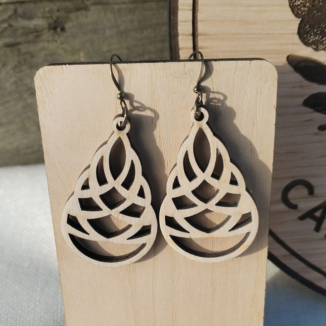 Wooden earrings on a wooden stand with a blurred background