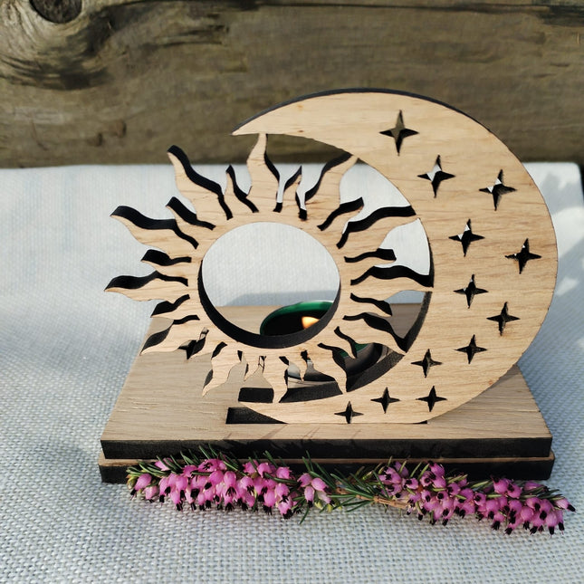 Wooden decorative item with sun and moon design on a table with flowers.