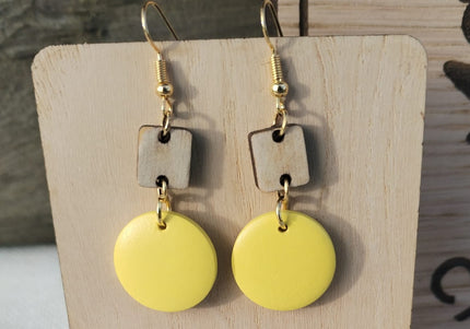 Yellow earrings on a wooden stand with a floral background