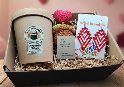 Gift box with lavender fields candle, earrings, and other items on a purple background