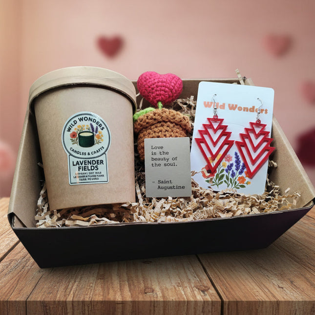 Gift box with lavender fields candle, earrings, and other items on a purple background